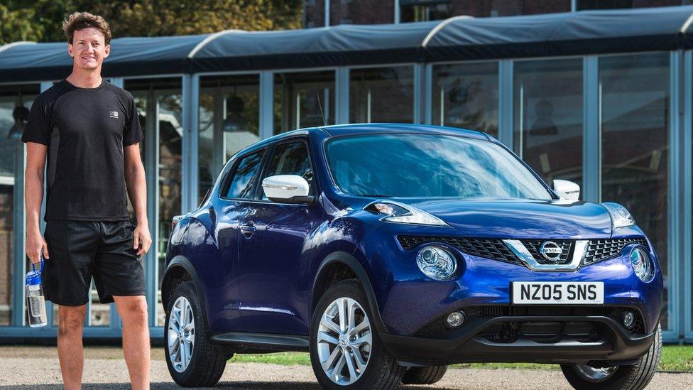 Man standing in front of Nissan car