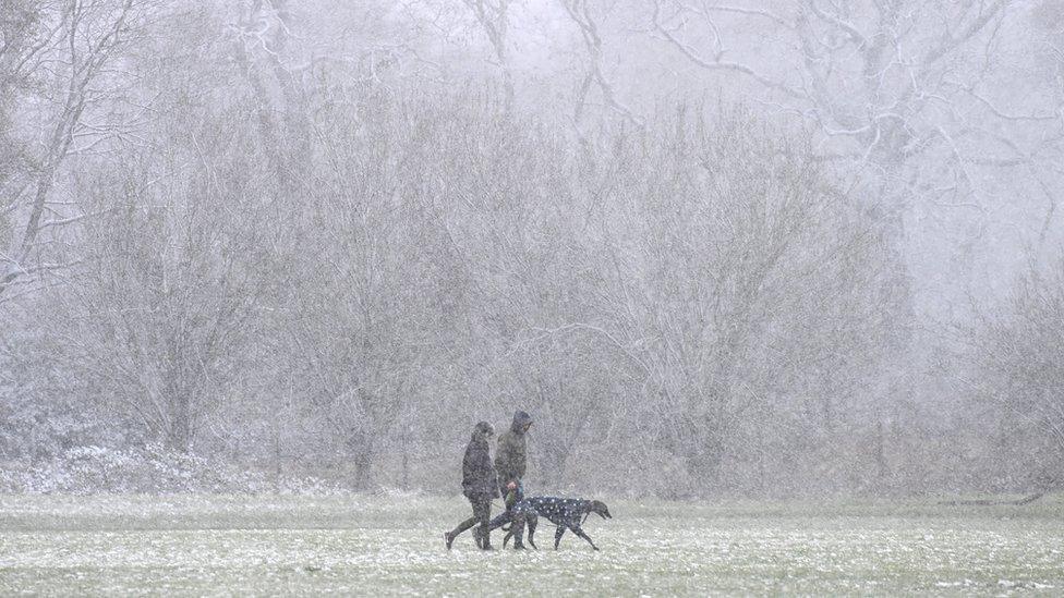 Pedestrians walk in the snow in Beckenham Place park in south east London