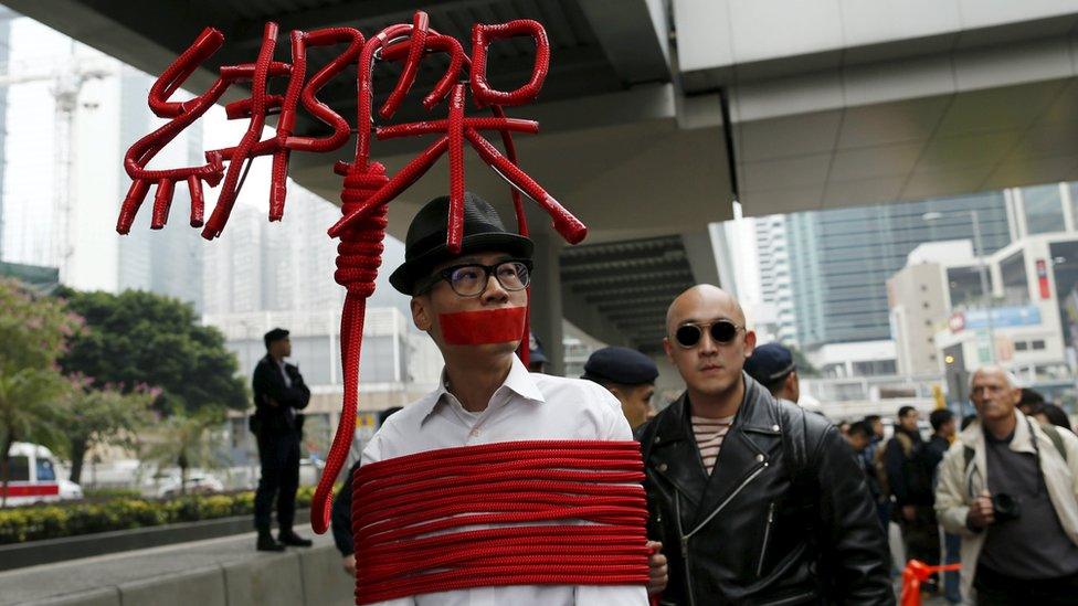 A protester ties himself in rope in a protest over the disappearance of Hong Kong booksellers