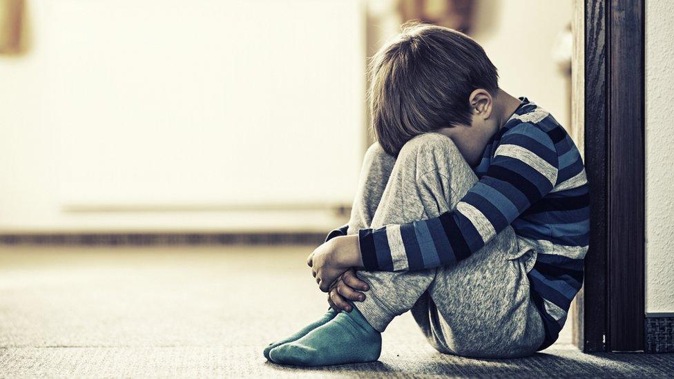 Child sitting in doorway