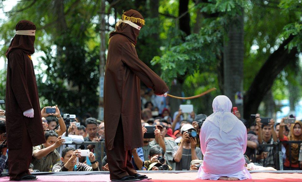 Indonesian woman being flogged in front of audience with smartphones