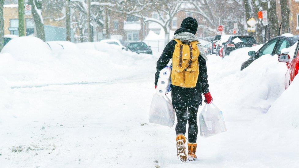 Woman carrying shopping in the snow