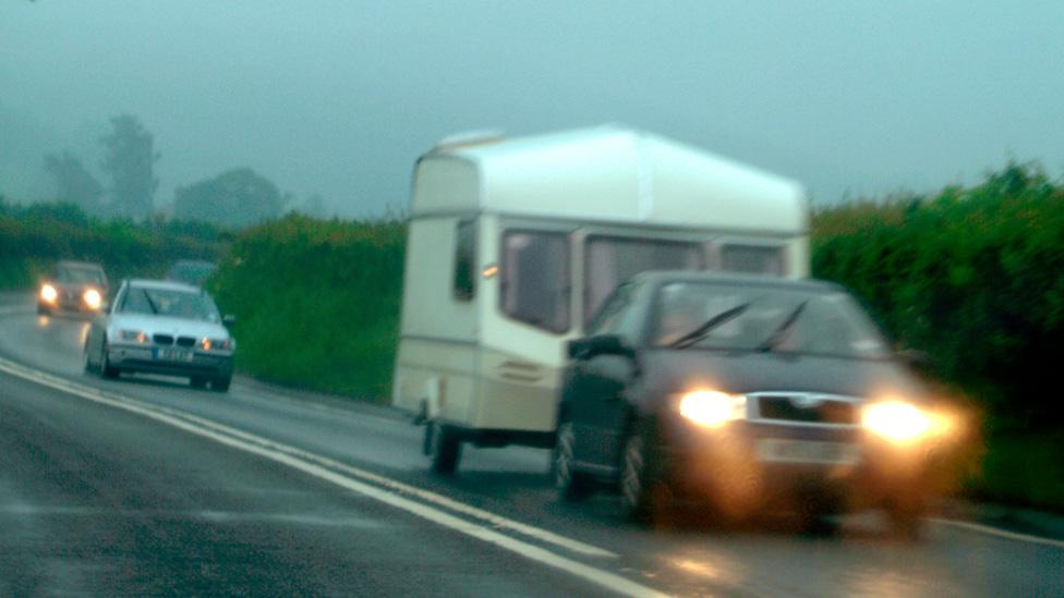 Driver towing caravan in rain