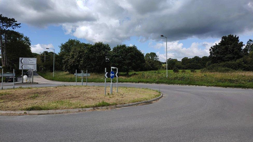 Half a roundabout with a field beyond