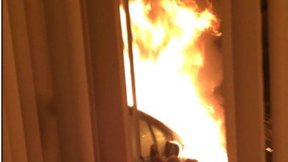 An image of the burning car taken from inside the house