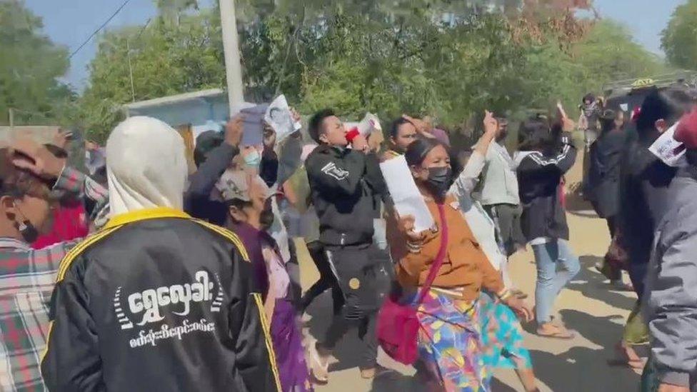 People chant as they march along a street during a protest against the military coup in Mandalay, Myanmar February 9, 2021, in this still image obtained from a social media video.