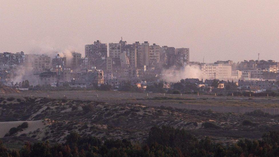 Smoke rises amid damaged buildings in the Gaza Strip