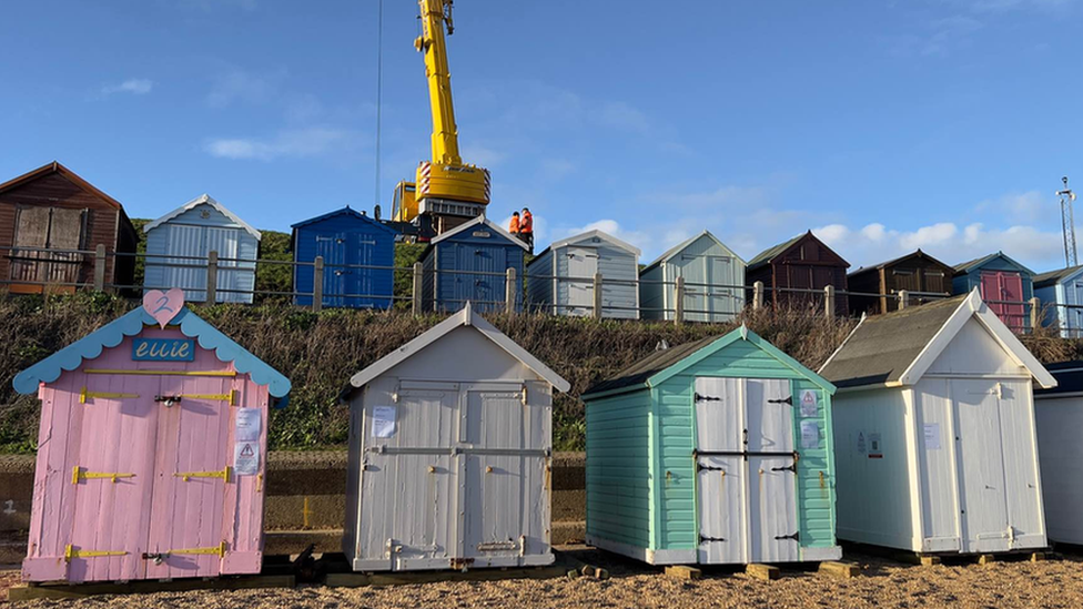 A crane lifting up one of the beach huts at Felixstowe beach