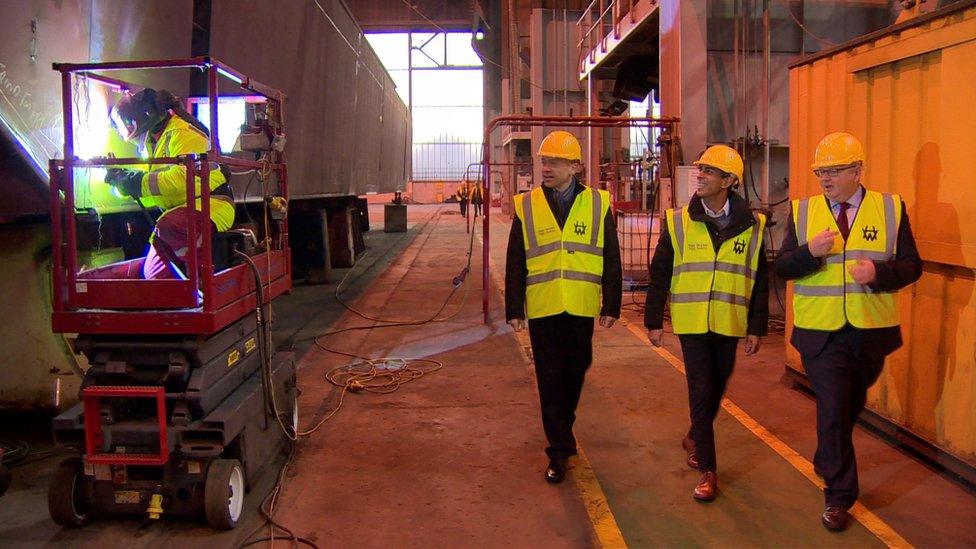 Chris Heaton-Harris, Rishi Sunak and an executive from the Harland and Wolff shipyard watch a welder at work