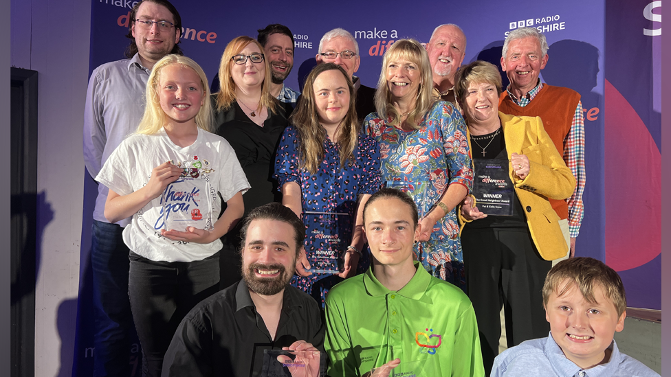 All the winners at the Make a Difference Awards, smiling and holding their awards