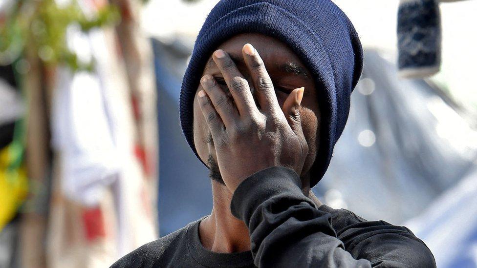 A migrant gestures outside the headquarters of the International Organisation for Migration (IOM) in Tunis, on March 7, 2023