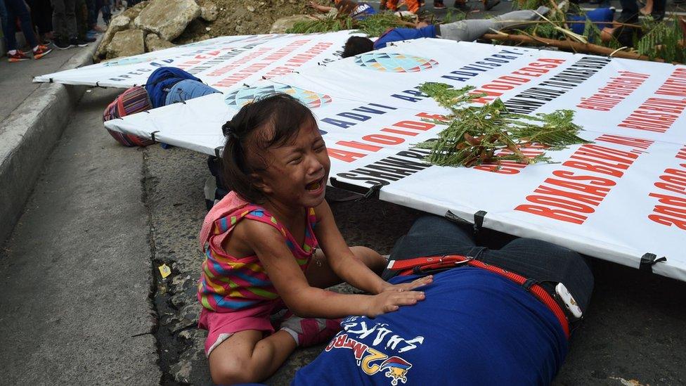 A young girl cries as her mother acts as an injured victim during an earthquake drill as part of the metro-wide quake drill in Manila on June 22, 2016.