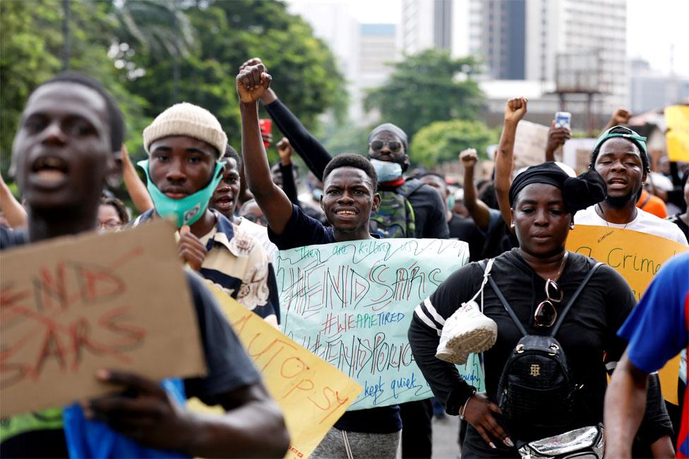 Protesters carry placards