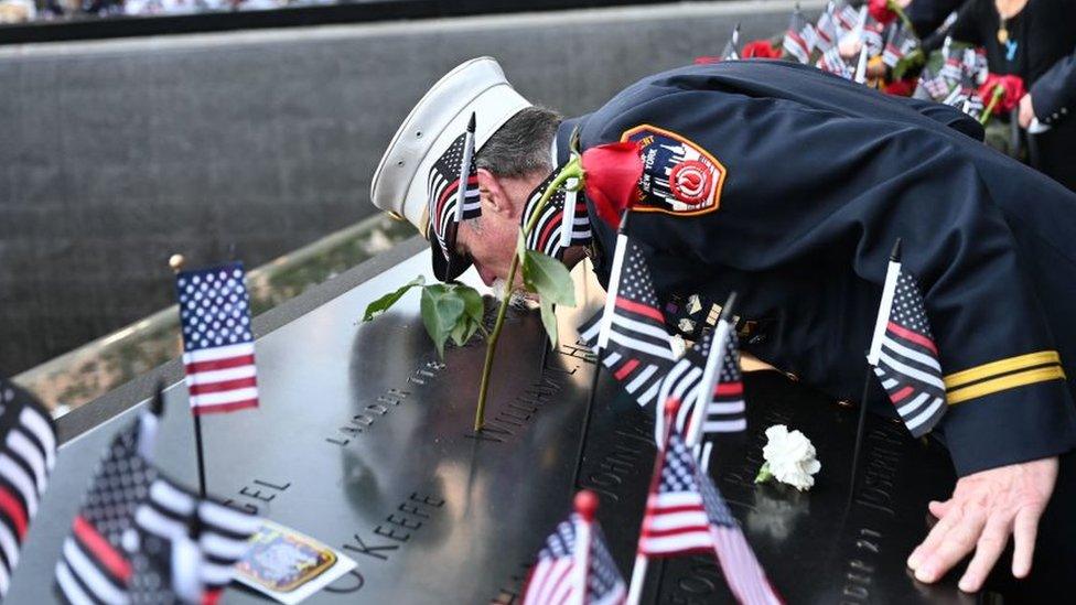 Retired Paramedic Chief Charlie Wells kisses the name of a relative killed in the attack on the World Trade Center