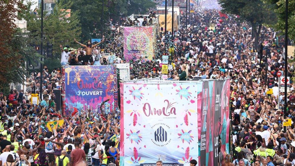 Different music buses weave through crowds during the parade