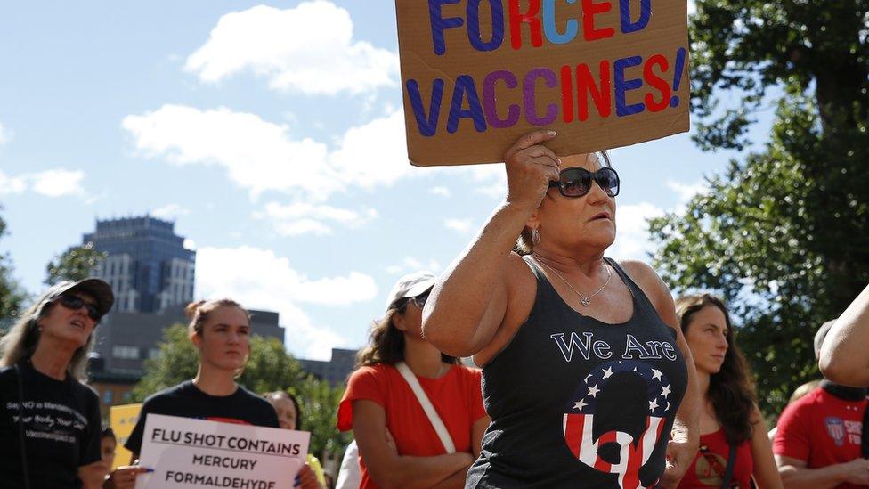 A anti-vaccine protester wearing a QAnon t-shirt in Boston on Sunday