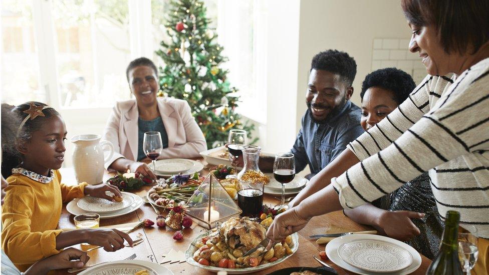 Family around dining table at Christmas.