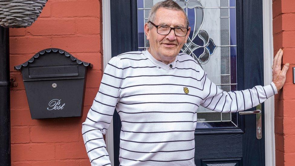 a man in a striped top standing by a door