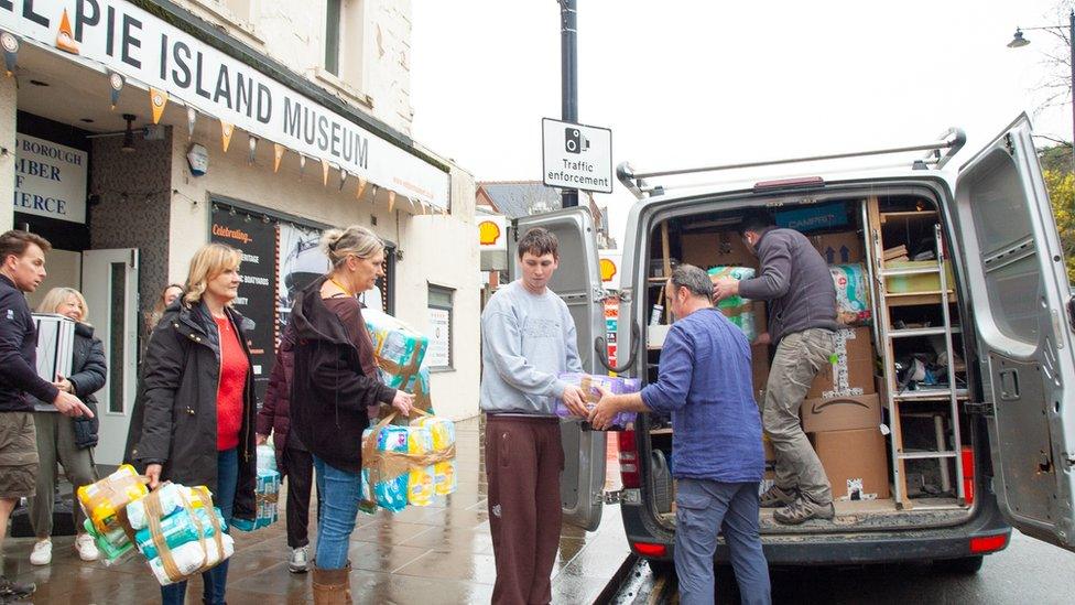 People load donated items into a van