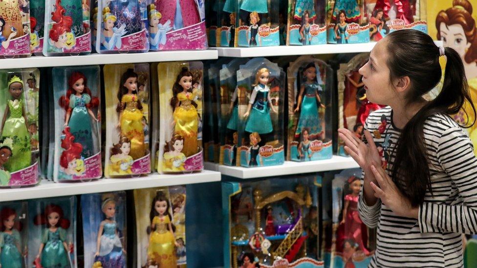 A girl looking at Disney Princess dolls