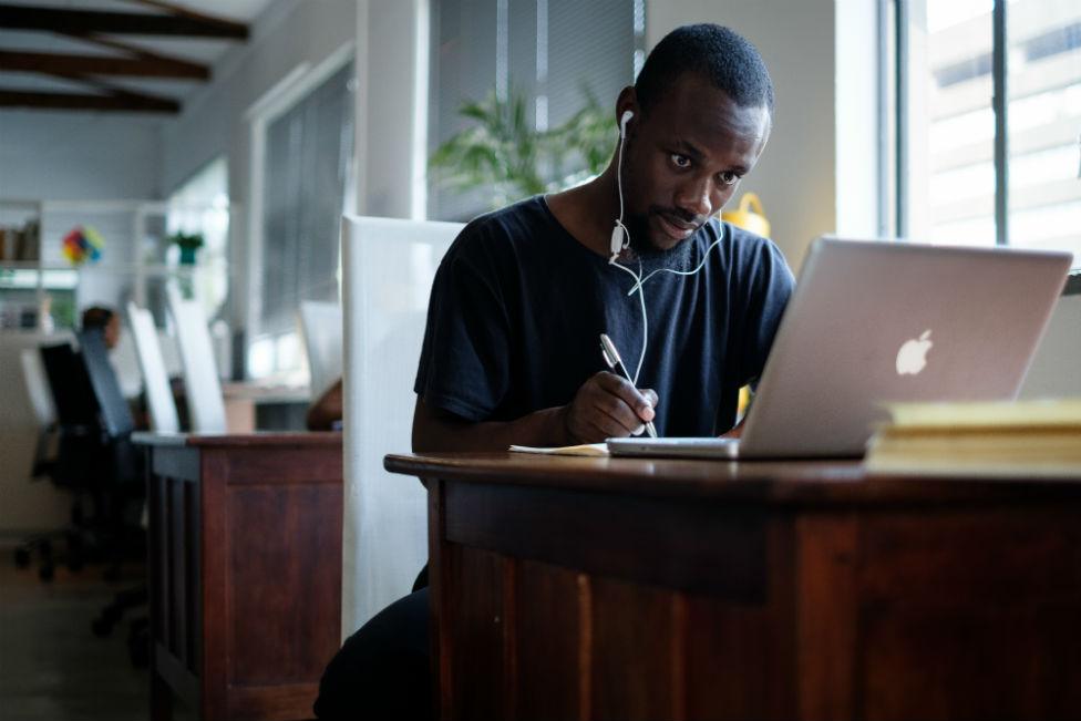 Young black South African sits at a computer