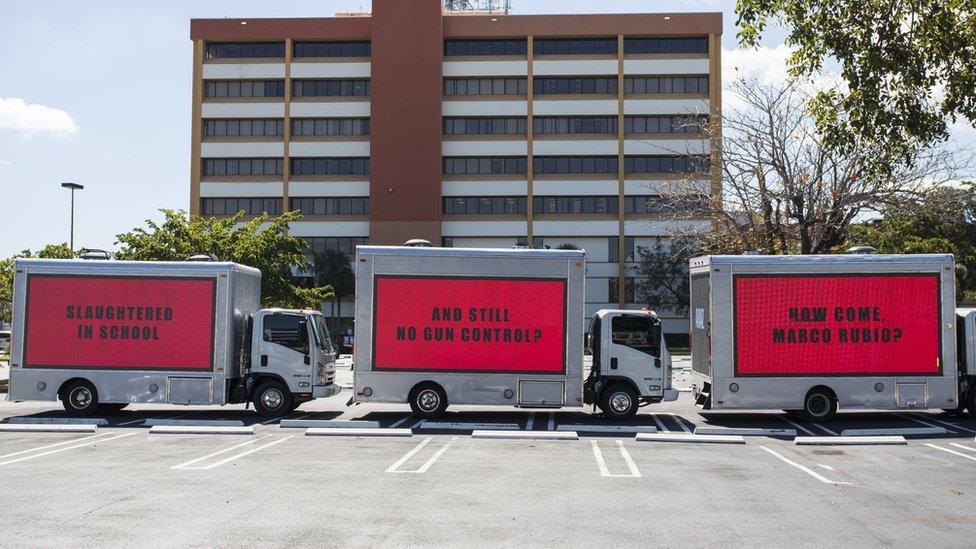 Three buses saying: "Slaughtered in school", "and still no gun control?", "How come, Marco Rubio?"