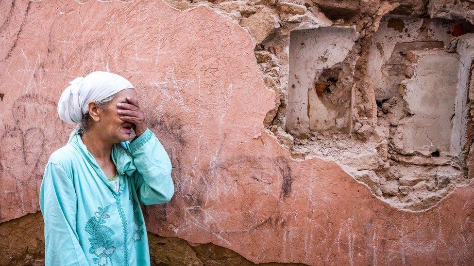 A woman standing in front of her earthquake-damaged home in Marrakesh on 9 September