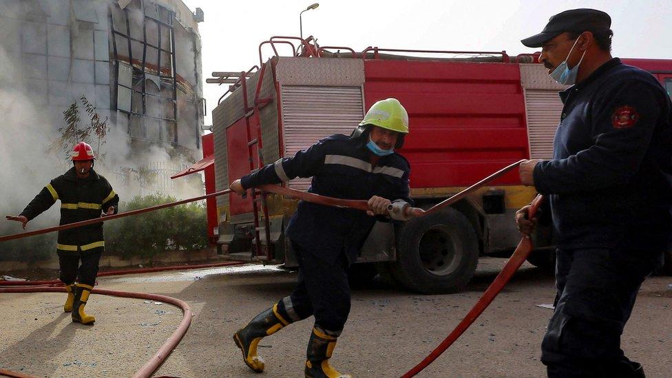 Firefighters extinguish the blaze in a clothing factory on the eastern outskirts of the Egyptian capital Cairo, on 11 March, 2021