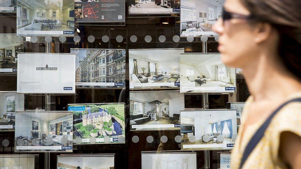 Woman walking past estate agents