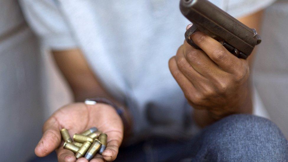 A young gang member shows a gun and ammunition, in Bonteheuwel neighbourhood in Cape Town, South Africa on 17 November, 2012.
