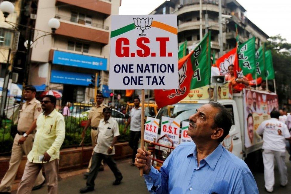 A supporter of India"s ruling Bharatiya Janata Party (BJP) holds a placard during a rally to support implementation of the Goods and Services Tax (GST) in Mumbai, India, June 30, 2017