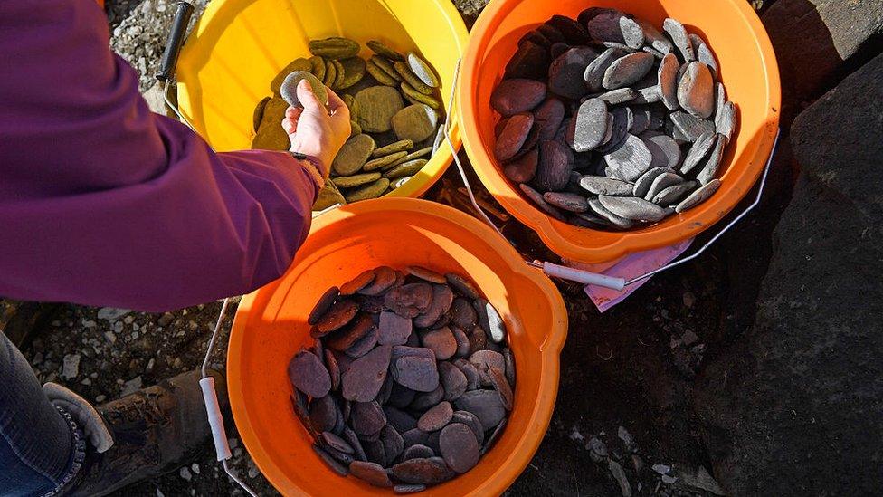 EASDALE, SCOTLAND - SEPTEMBER 25: Competitors select their stones during the World Stone Skimming Championships, held on Easdale Island on September 25, 2016 in Easdale, Seil, Scotland. The championships marking its 20th year are held on the last Sunday in September each year on Easdale, which is the smallest inhabited island of the Inner Hebrides.