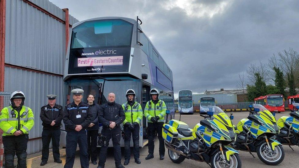 Norfolk Police officers in front of a double-decker bus