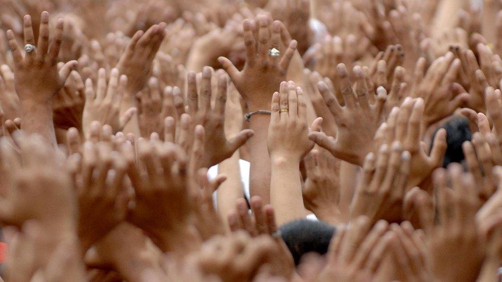 Hands are raised as thousands of Catholic pilgrims jostle in a yearly tradition in the Philippines