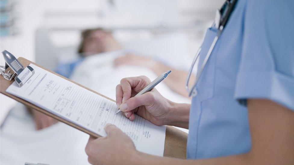 Nurse tending patient (stock photo)