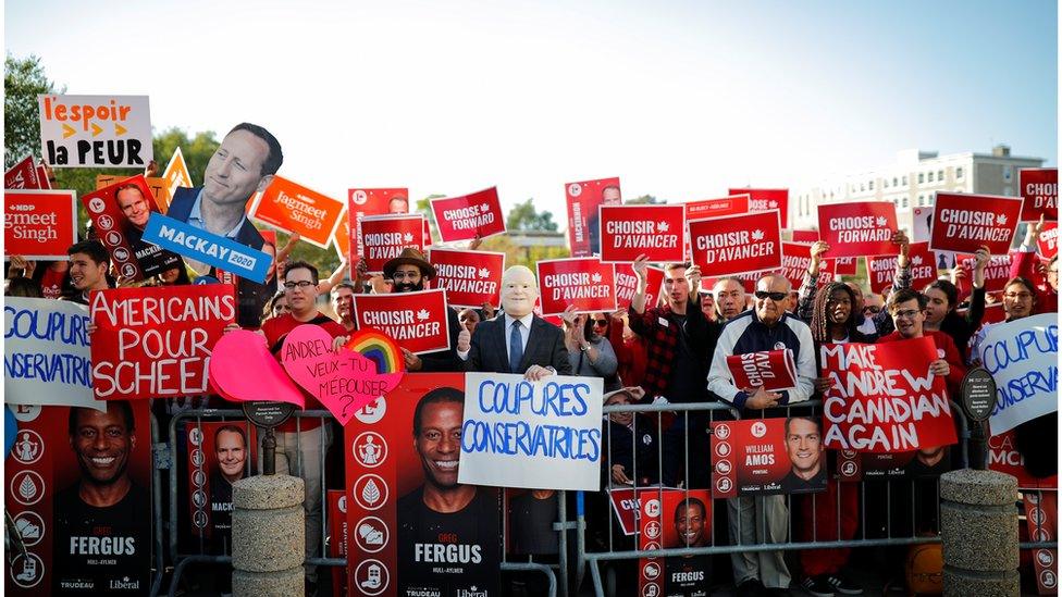 A crowd of partisan supporters await the arrival of the party leaders to the debate venue