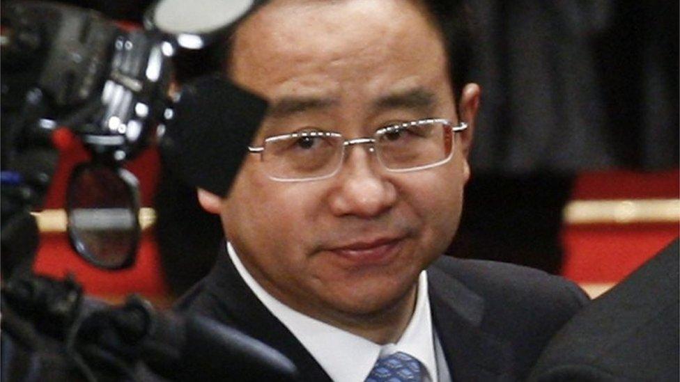 In this March 14, 2012, file photo, Ling Jihua, a loyal aide and confidante to President Hu Jintao, is seen as Chinese President Hu Jintao signs a document after attending the closing ceremony of the National People's Congress at the Great Hall of the People in Beijing.