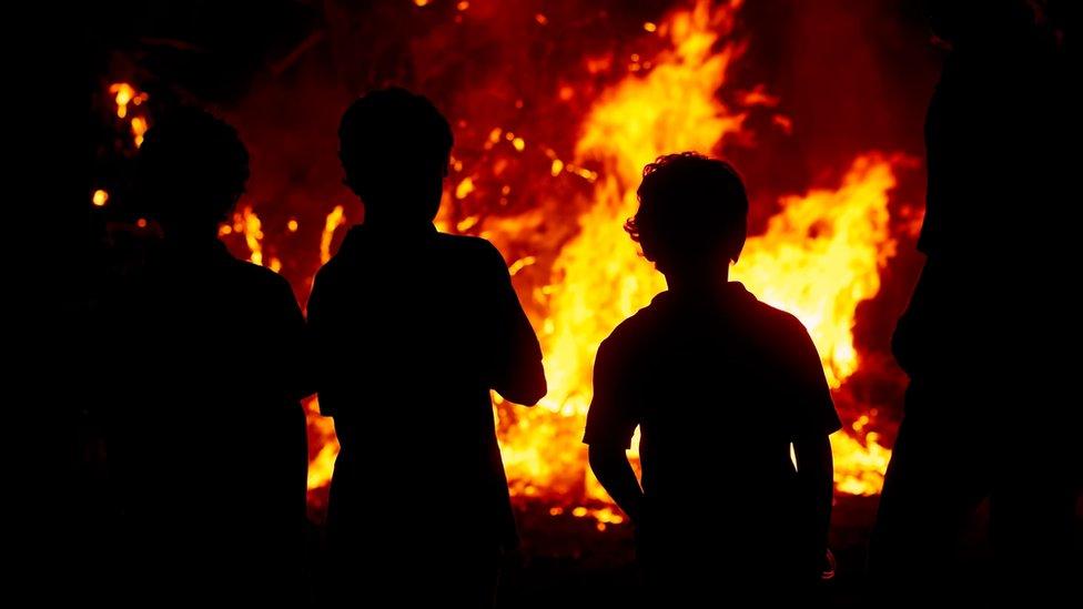 Children watching a bonfire.