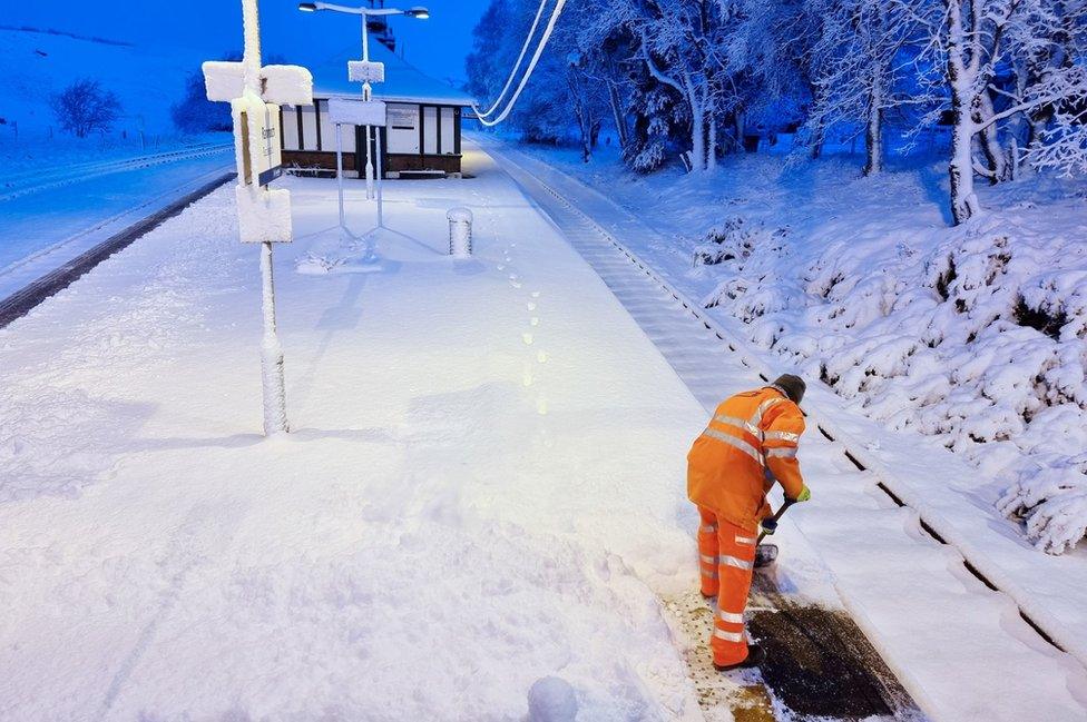 A railway worker clears snow from the platform at Rannoch Station