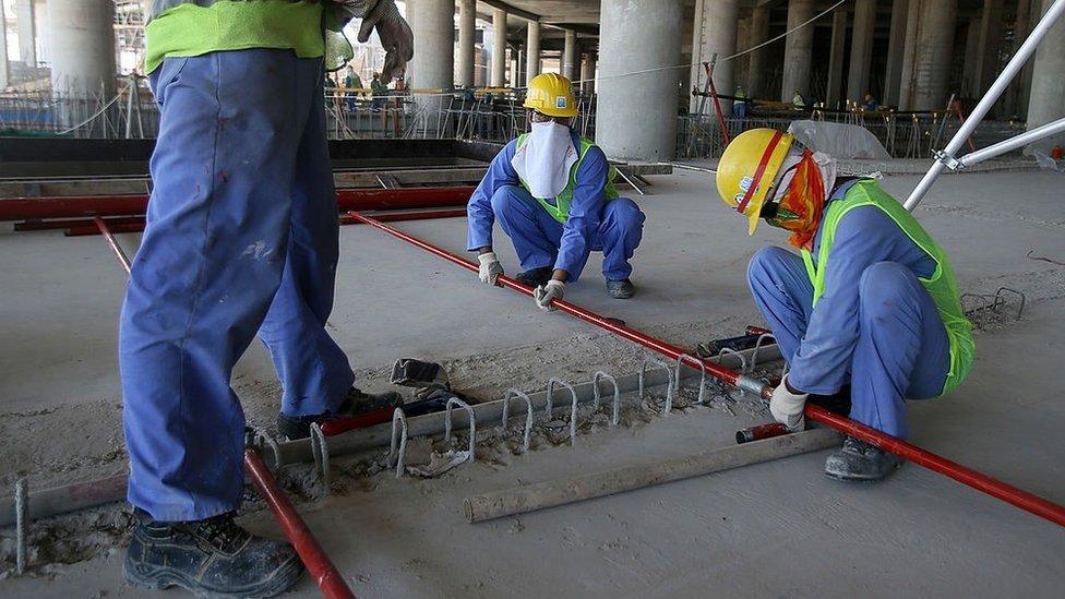 Migrant labourers work on a Qatar construction site