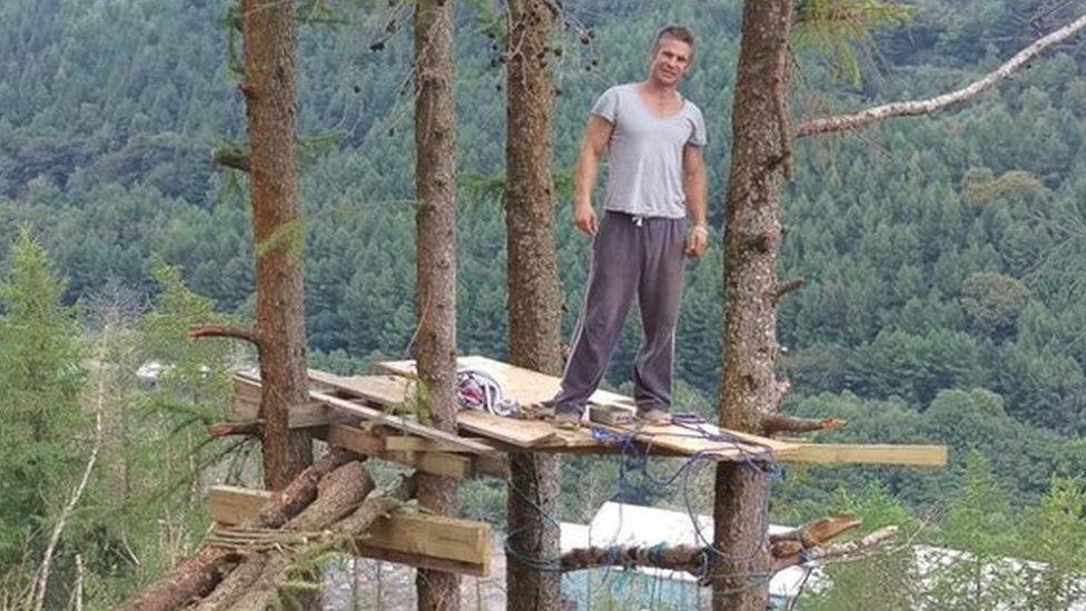 Mike Allen standing on a platform in the trees