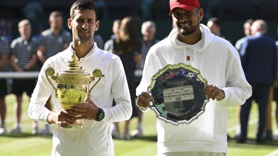 Serbia's Novak Djokovic poses with the trophy after winning the men"s singles final alongside runner up Australia"s Nick Kyrgios