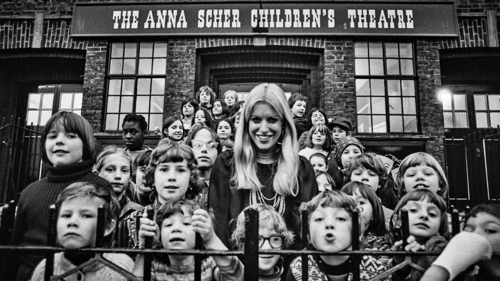 Scher is pictured outside her school with pupils in 1977