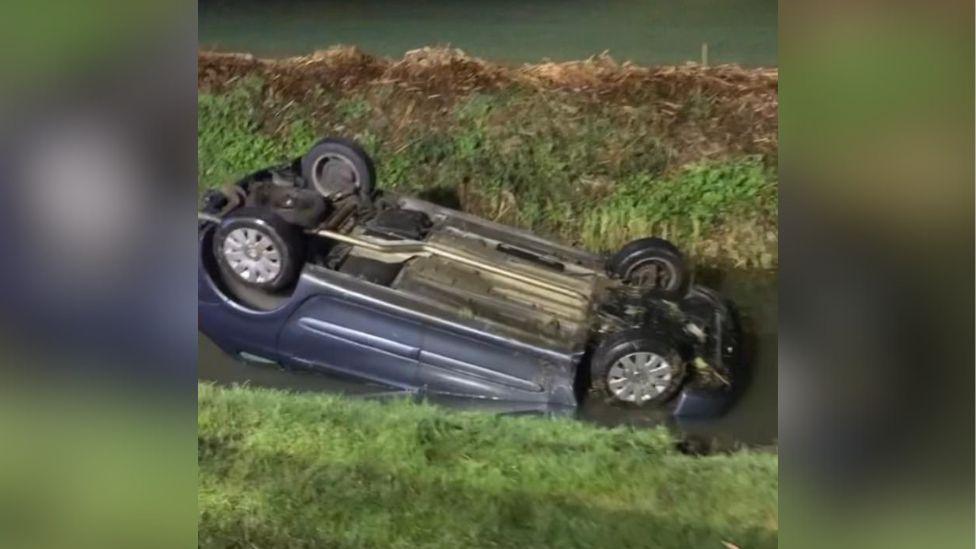 Car upside down in ditch