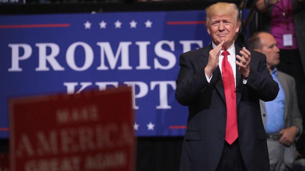 Donald Trump claps at a rally in Iowa.