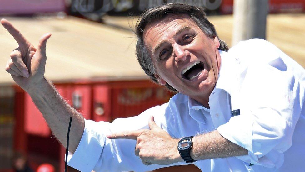 Jair Bolsonaro makes his trademark rifle gesture during a rally on 5 September