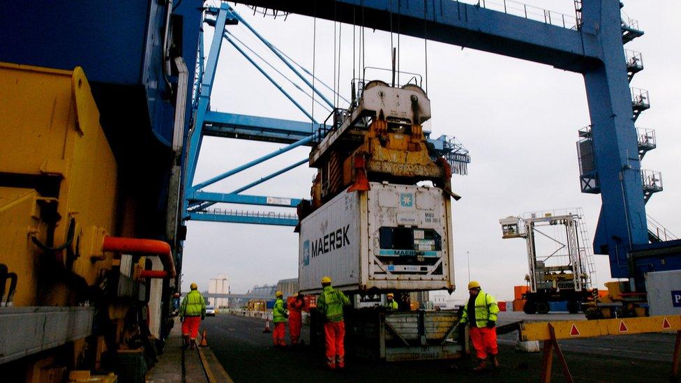 Staff unload shipping containers at Tilbury Dock