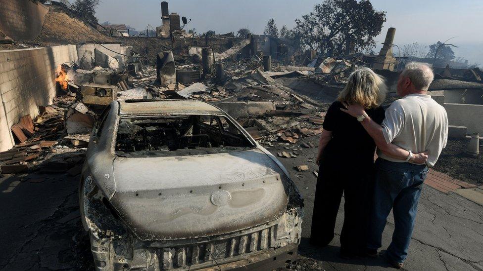 A couple assess the damage caused by the wildfires.