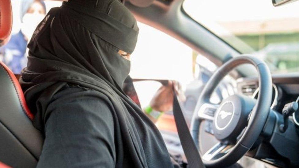 Woman sits in the driving seat of a car