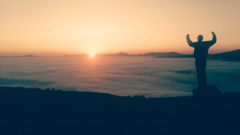 Jake Spencer above the clouds and sun near the summit of Foel Senigl in Gwynedd